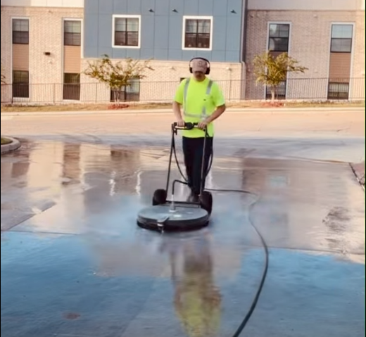 Concrete cleaning service - surface cleaner removing stains from commercial parking area