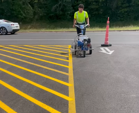 Parking lot painting service - line striping machine painting yellow parking lines