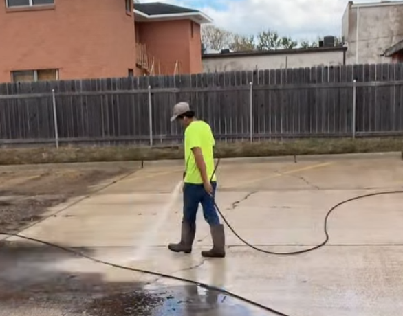 Pressure washing service - technician cleaning concrete driveway in Shreveport Louisiana